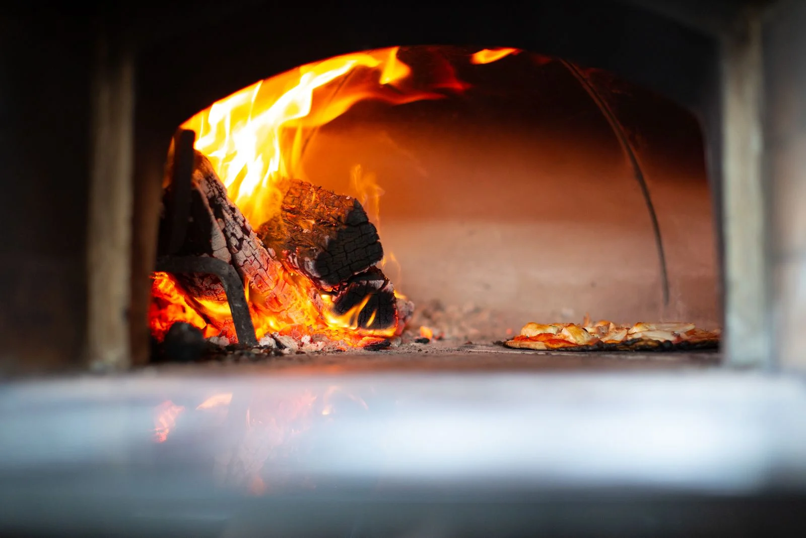 Burning logs inside a wood-fired oven.