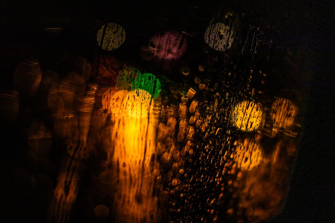 Colored lights seen through rain-covered glass.